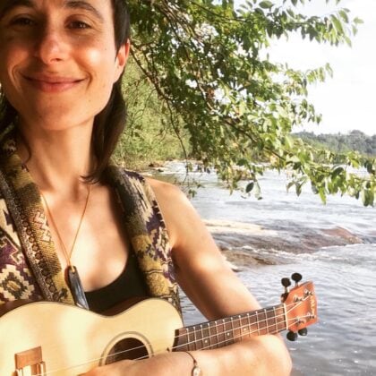 woman with ukulele near water